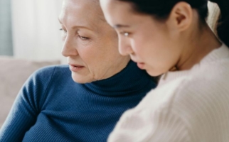 Närbild på en mamma och dotter som sitter tillsammans, en bild som speglar samtal, närhet och att stärka relationen till sitt barn.