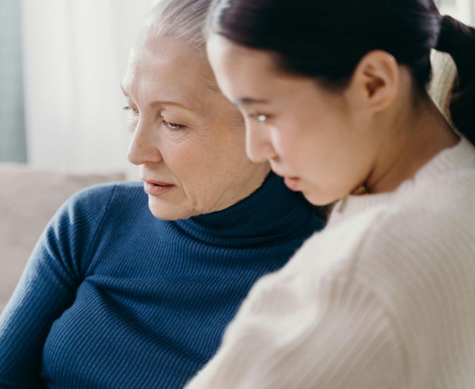 Närbild på en mamma och dotter som sitter tillsammans, en bild som speglar samtal, närhet och att stärka relationen till sitt barn.