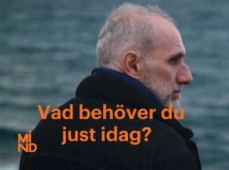 Profilbild av en man med svart kappa och blå halsduk