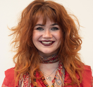 Matilda Holmberg med rött vågigt hår och röd blus.
